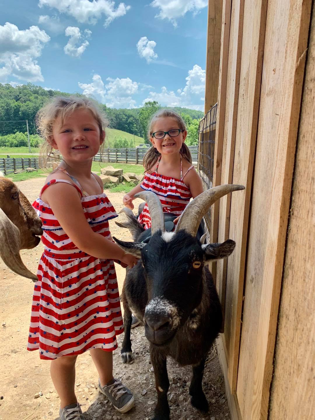 2 girls with goat outside