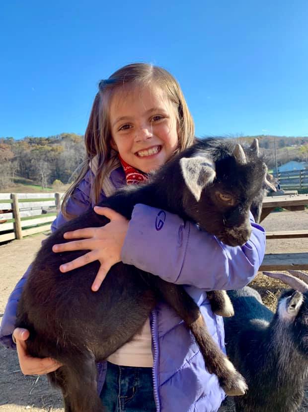 hugging goat, little girl